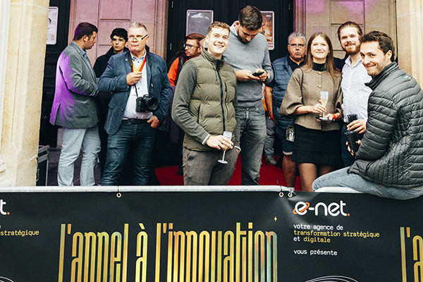 Une foule prenant la pose devant une bannière ou l'on peut lire "l'appel à l'innovation"