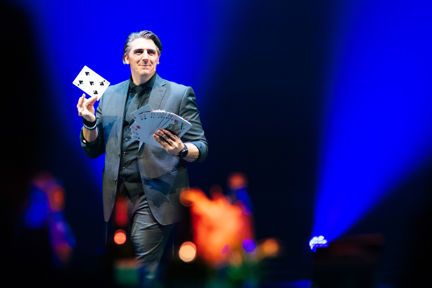 Plan du mentaliste Benjamin Ghislain en pleine action, une carte de jeu à la main.