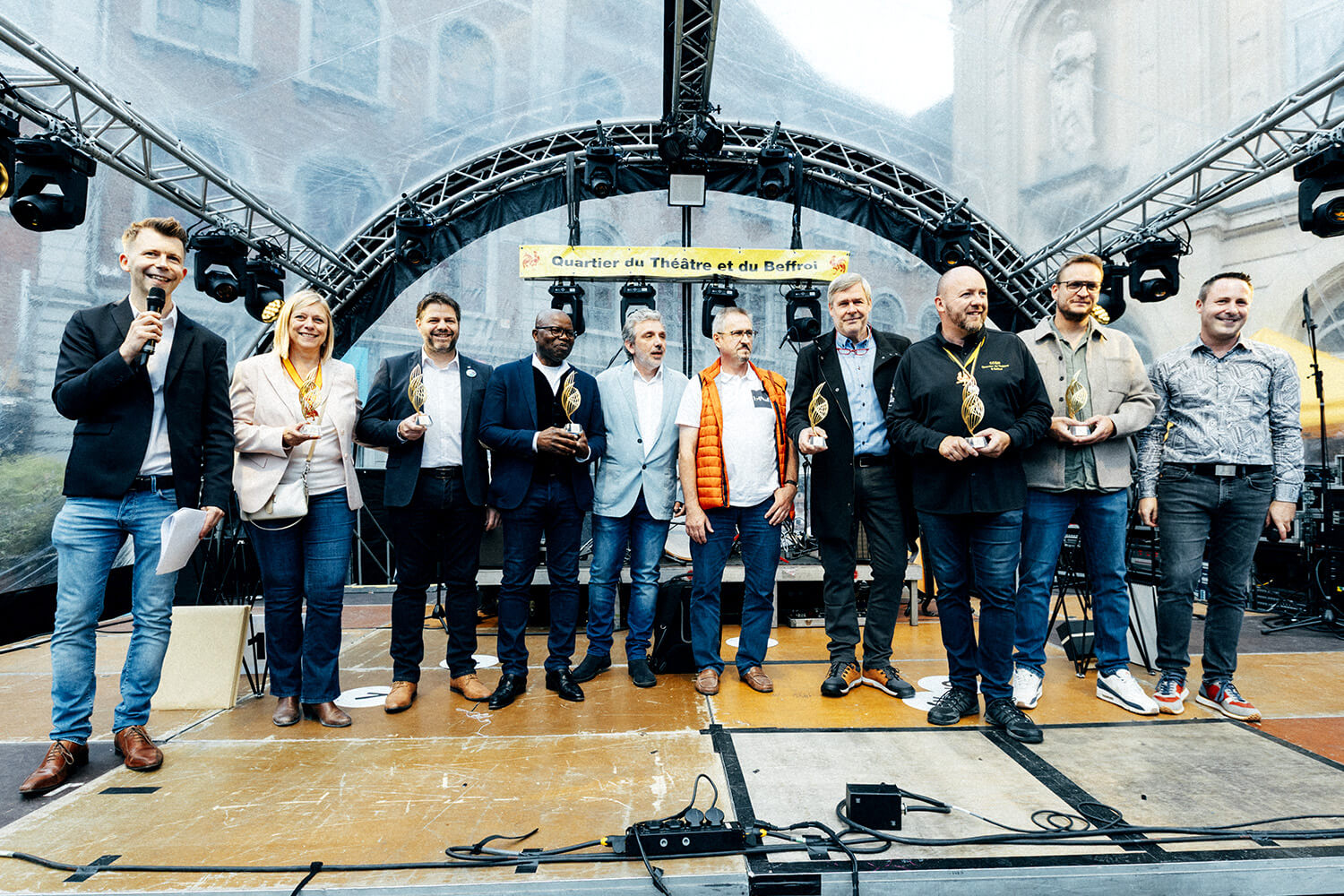 Un groupe de lauréats, dont des personnalités politiques et des entrepreneurs, pose ensemble sur scène avec leurs trophées du Prix du Souffle de l’Innovation. L’ambiance est conviviale et unie.