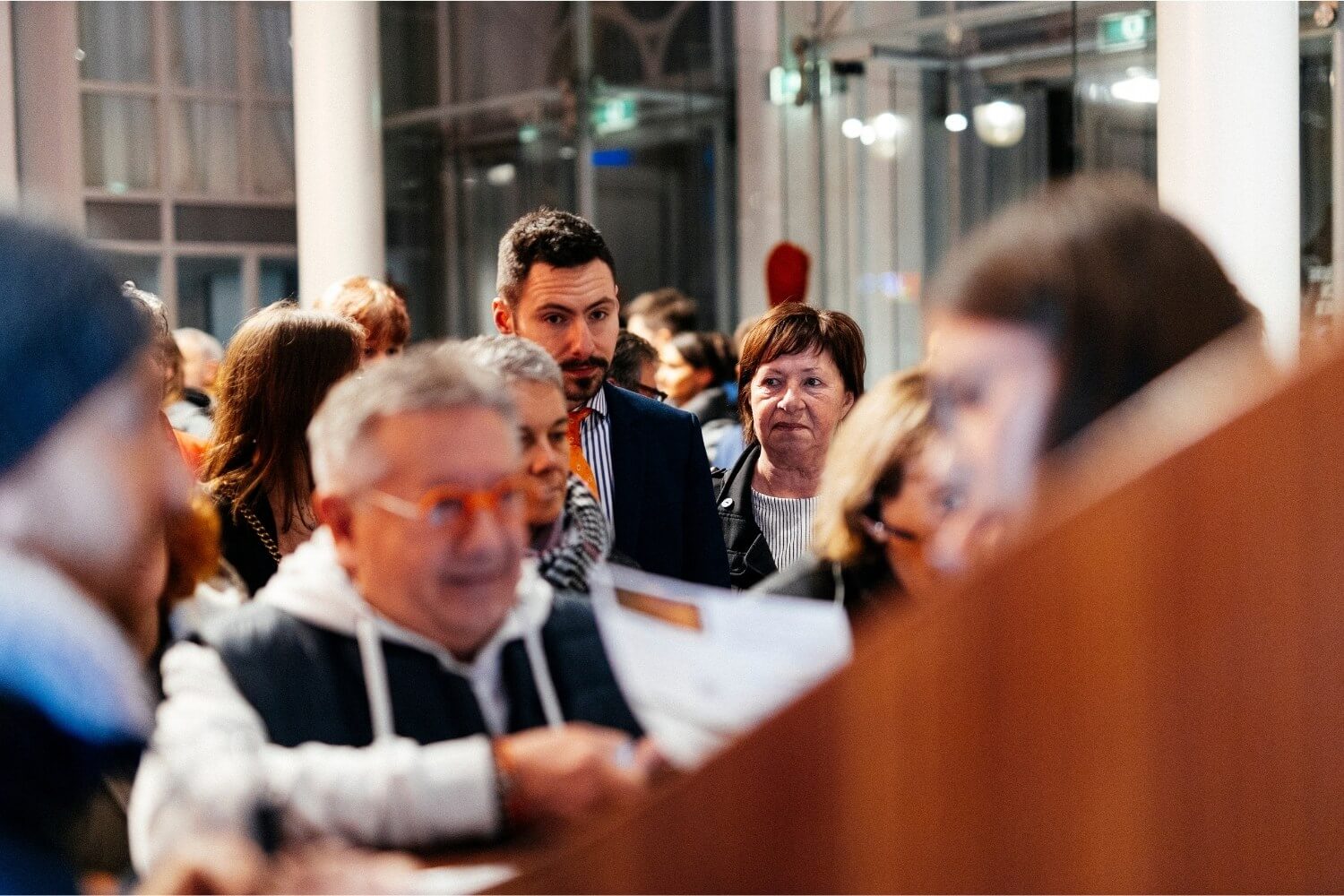 Participants de profils variés patientant à l’entrée du Théâtre Royal de Namur, illustrant la diversité des horizons réunis autour des enjeux Humain–IA.