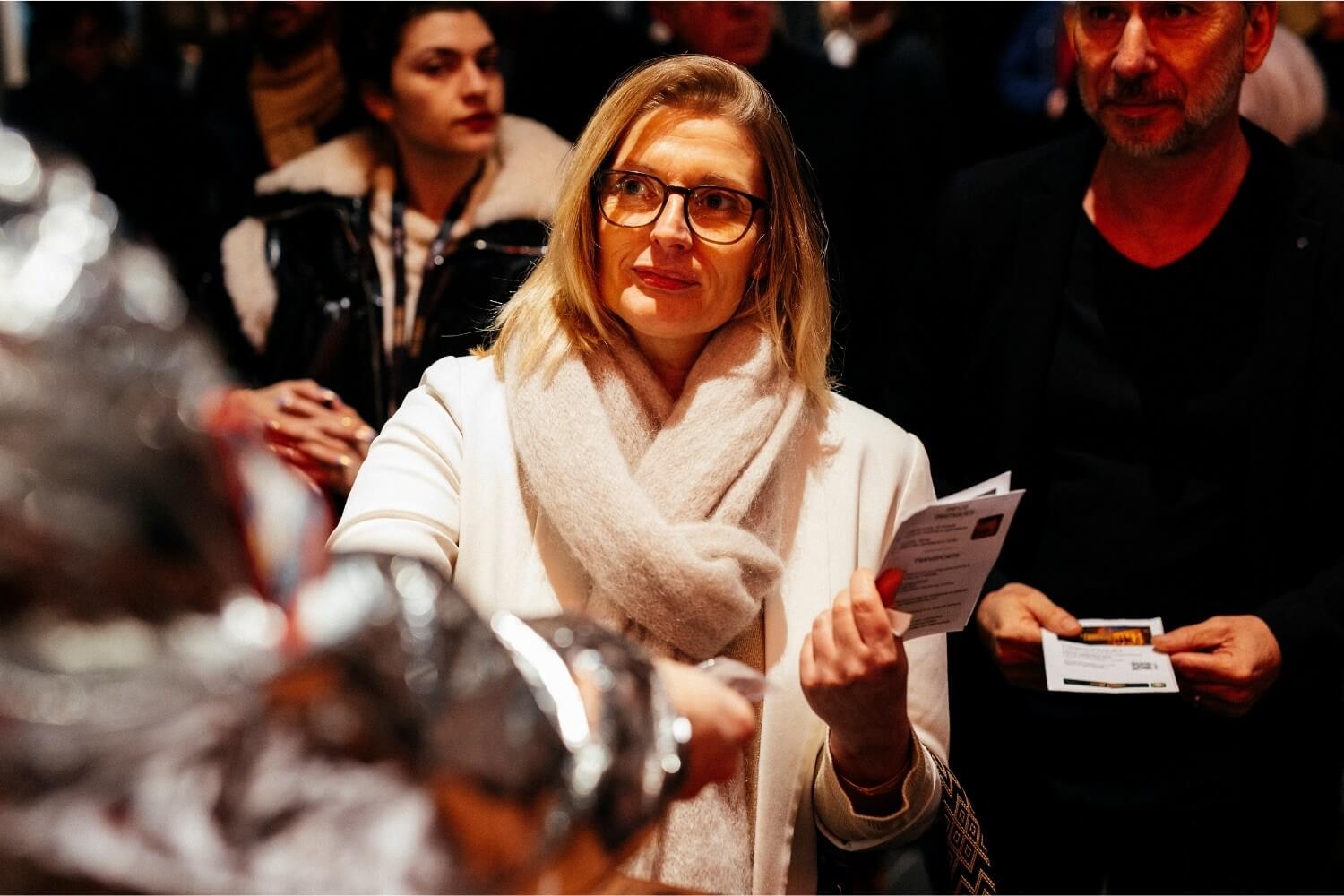 Contrôle des billets à l’entrée du théâtre, où l’échange humain marque la transition entre le quotidien et l’expérience immersive de la soirée.