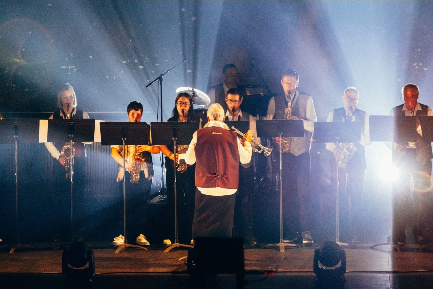 Les musiciens de la fanfare Sainte-Cécile d’Assesse interprètent le thème musical en direct, incarnant la force du collectif et la transmission humaine face à la technologie.