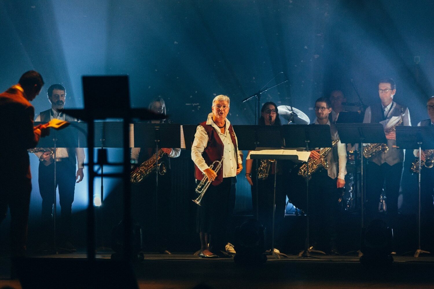 Nicolas Pourbaix rejoint la fanfare Sainte-Cécile d’Assesse sur scène, illustrant la complémentarité entre innovation technologique, émotion collective et leadership humain.