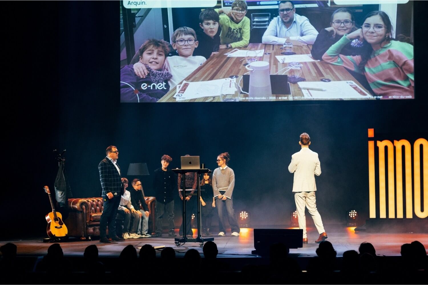 Simon Arquin présente le projet ABP Robotics aux côtés d’enfants sur scène.